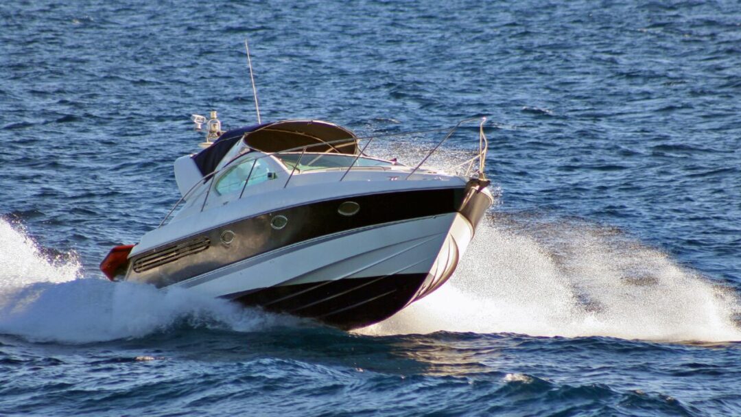 White and black speedboat turning through waves
