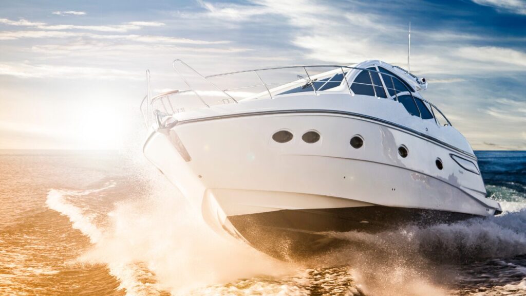 White motor boat speeding across the sea at sunset